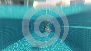 Sportive young man swimming breaststroke style in swimming pool, underwater view. Action camera