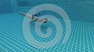 Sportive young man in the swimming pool, underwater view. Vacation summer time. Action camera