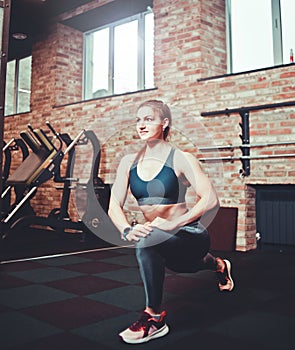 Sportive young woman training at gym