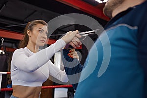 Sportive young woman training self-defense from attacker with gun weapon photo