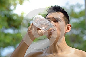 Sportman drinking a bottle of water outdoor.. photo