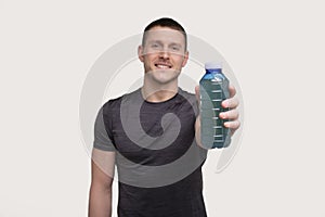 Sportman Showing Sport Drink. Energy Drink for Sport. Man with Drink in Hands.