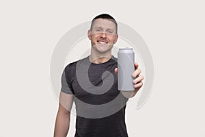 Sportman Showing Tin Can Drink. Energy Drink for Sport. Man with Can in Hands. photo