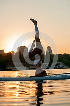 Girl training yoga in nature during sunset