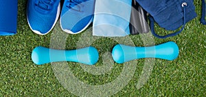 sports background. on the green lawn, are blue items for fitness outdoor, sneakers and a bag. jump rope and things