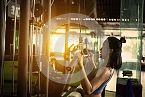 Sports background. Muscular fit woman exercising in fitness gym. on a cable machine simulator.