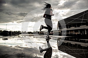 Sports background. Strong athletic legs of a woman runner in motion. Morning workouts outdoors after the rain