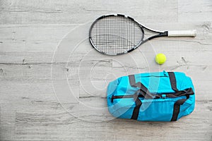 Sports bag, racket and ball on wooden floo photo