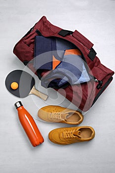 Sports bag and table tennis equipment on white  background, flat lay
