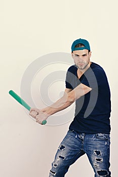 Sports and baseball training concept. Guy in dark blue tshirt holds bright green bat