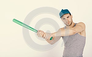 Sports and baseball training concept. Guy in grey tank top holds bright green bat.