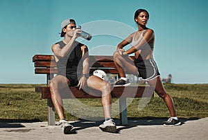 Sports, bench and fitness people with water bottle in a park for outdoor training, workout or wellness with blue sky
