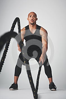 Sports, black man and battle rope for fitness, strength and building of muscle, power and endurance. Speed, action and