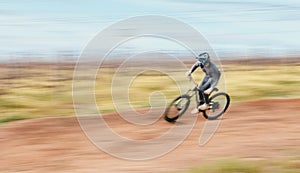 Sports, blur and man riding a bike in nature training for a race, marathon or competition. Fitness, motion and male