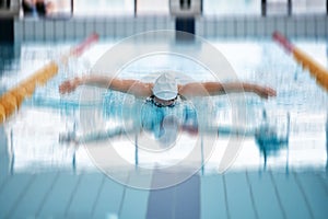 Sports, butterfly or girl training in swimming pool for a race competition, exercise or cardio workout. Blurry swimmer