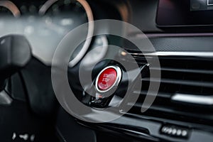 Sports car dashboard with focus on red engine start stop button. Button engine start and engine stop. Car inside