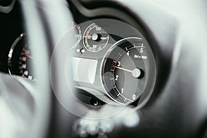Sports car dashboard and steering wheel with tachometer and fuel indicator