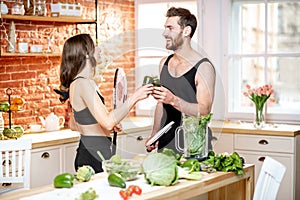 Sports couple eating healthy food on the kitchen at home
