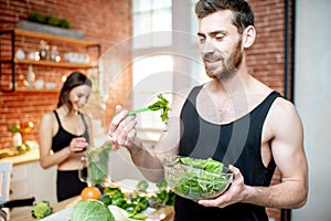 Sports couple eating healthy vegetarian food on the kitchen