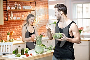 Sports couple eating healthy vegetarian food on the kitchen