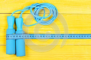 Sports equipment in cyan color. Measuring tape and jump rope