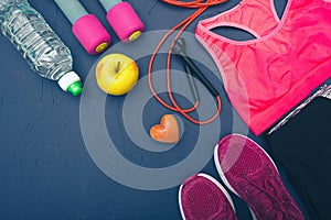 Sports equipment - dumbbells, an apple and a bottle of water, clothes and a jump rope