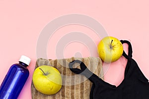 Sports equipment flat lay, yellow apples and water bottle, sneakers, black bra. Concept healthy lifestyle, sport and diet..