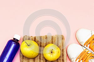 Sports equipment flat lay, yellow apples and water bottle, sneakers. Concept healthy lifestyle, sport and diet.