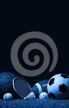 Sports equipment, rackets and balls on green grass with black background and copy space