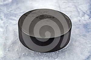 Sports equipment and team winter sport concept with closeup on hokey puck on ice rink photo