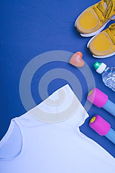 Sports equipment - white t-shirt, yellow sneakers, water bottle and dumbbells