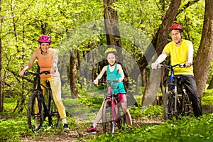 Sports family cycling in the beautiful forest