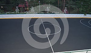 Sports field with markings for basketball and sports games, black modern floor covering, evening, outdoor
