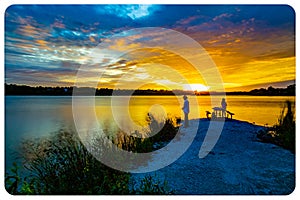 Sports Fishermen at Sunset early fall with beautiful water reflections and skyline over Ed Zorinsky lake Omaha Nebraska