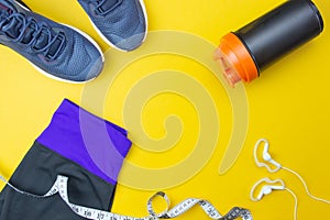 Sports flat layout. Fitness accessories sneakers, headphones, clothes, bottle on a blue background. Sports Planning