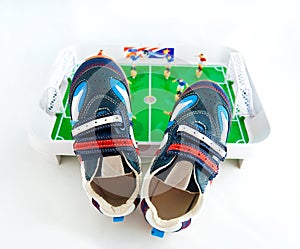 sports footwear against a toy football ground