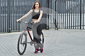 Sports girl with a bicycle in the city