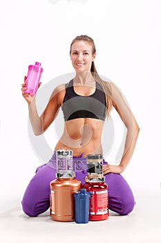 Sports girl with a cans of a protein and BCAA