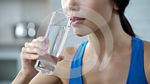 Sports girl drinking crystal clear water, restoring aqua balance after training