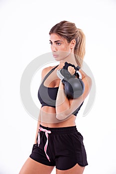 Sports girl with dumbbells in her hands on a light background