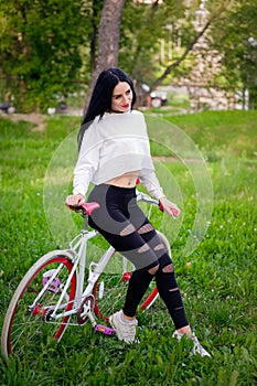 Sports girl rides a bicycle. emotions and lifestyle. Young beautiful woman riding a bike in the park. Active people. On the street