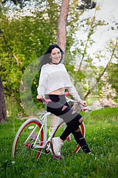 Sports girl rides a bicycle. emotions and lifestyle. Young beautiful woman riding a bike in the park. Active people. On the street