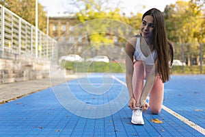 Sports girl tying laces in sneakers.