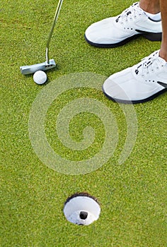 Sports, golf hole and shoes of person on course playing game, practice and training for competition. Professional golfer