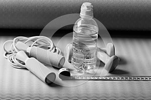 Sports and health. Workout and refreshment concept. Bottle or water near jump rope