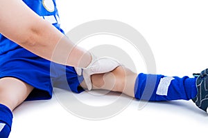 Sports injury. Doctor first aid at thigh of soccer player. Isolated on white.