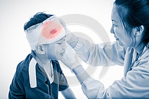 Sports injury. Doctor makes a bandage on head patient, on white.