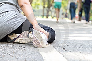 Sports injury. Woman with pain in ankle while jogging