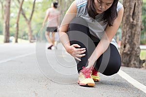 Sports injury. Woman with pain in ankle while jogging