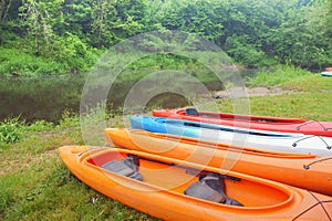 Sports kayaks on the shore of the pond, four kayaks on the Bank of the river